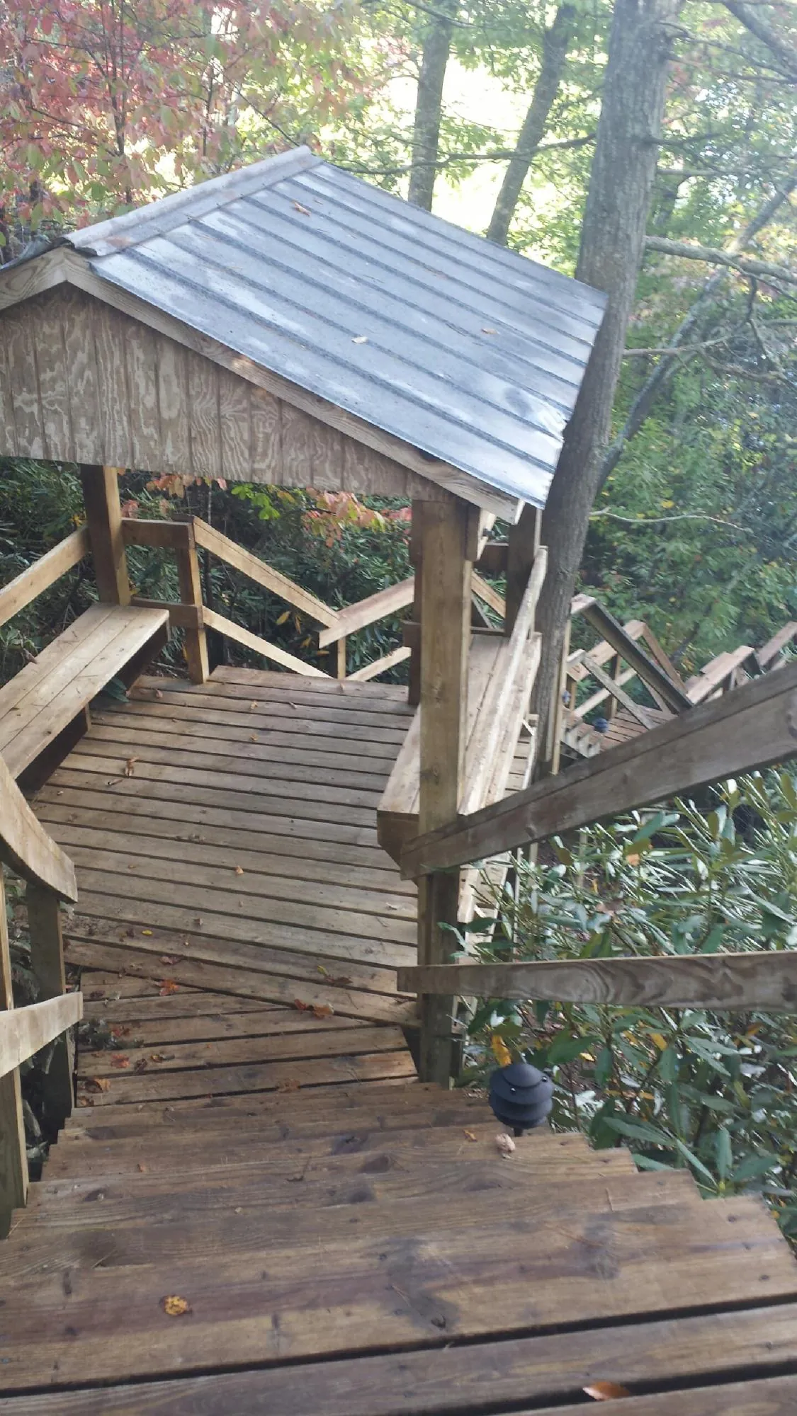 Metal roofed shelter over wooden steps on a wooded walkway — Skylight Repair & Installation work by our crew in Lawrenceville