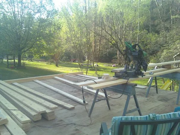 Miter saw and framing lumber on a deck under construction in Lawrenceville